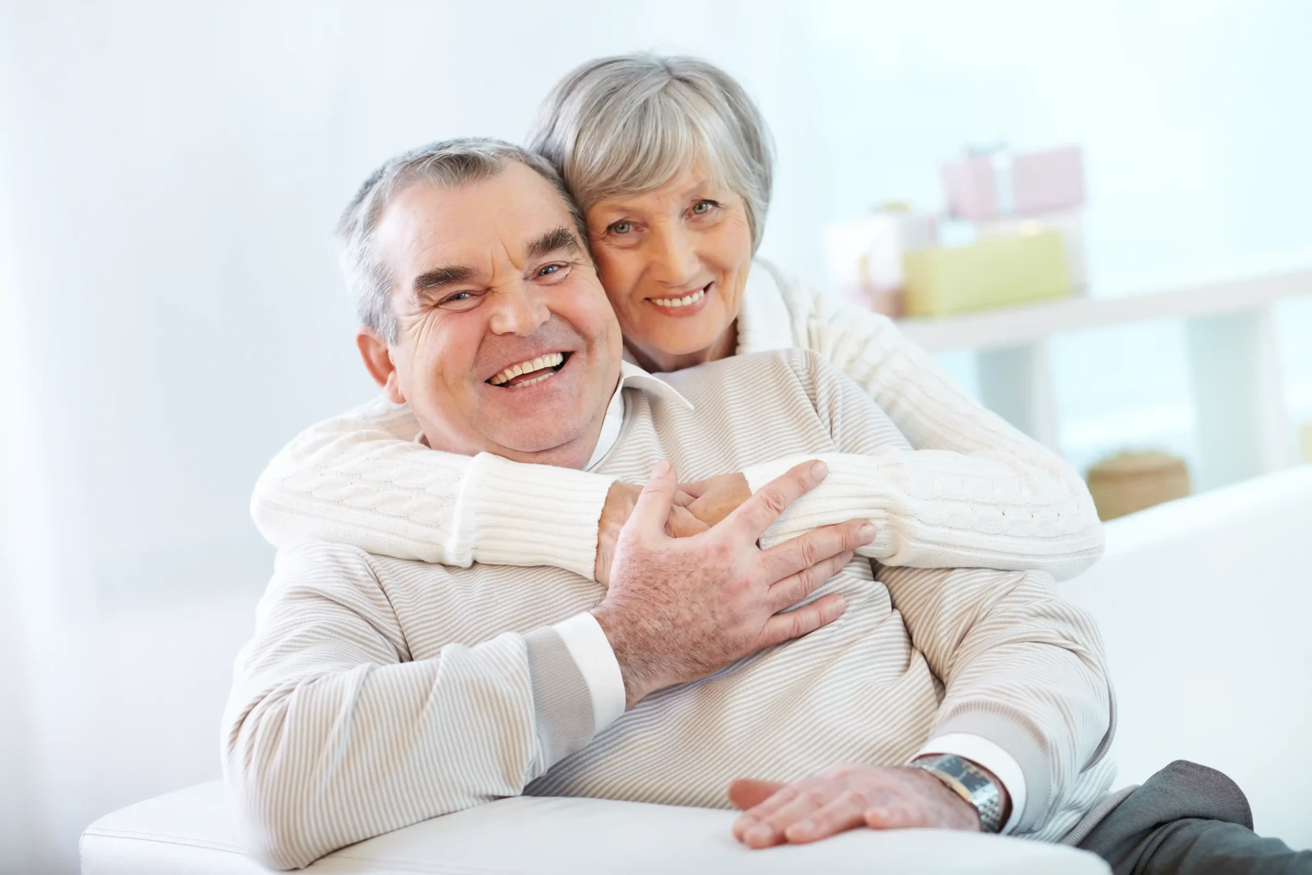 A senior couple hugging at home with dental implants